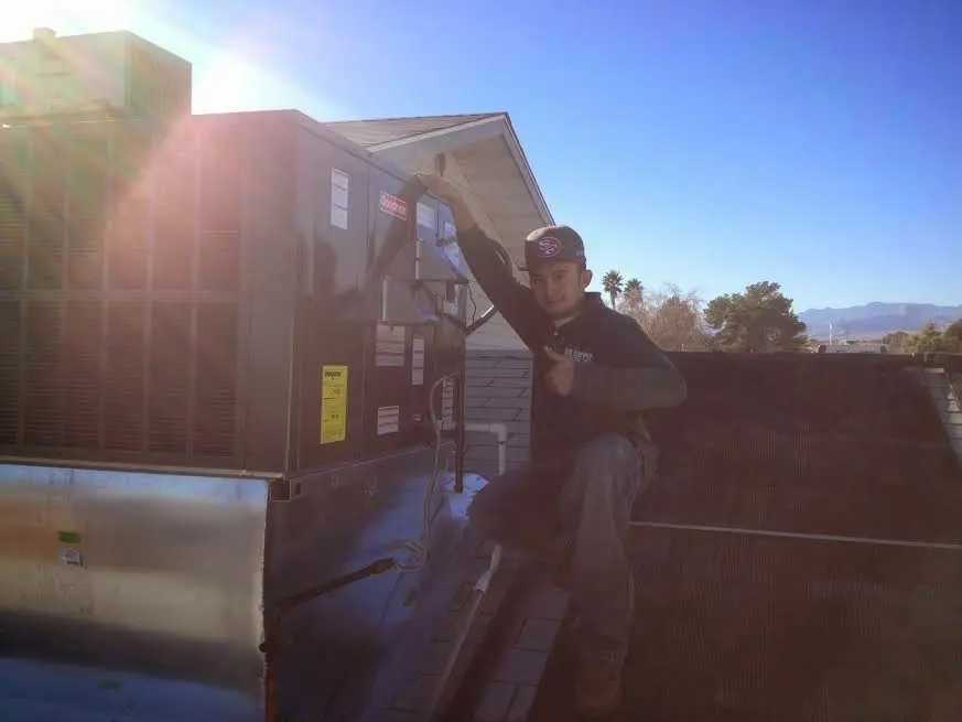 HVAC technician performing Boiler Repair on a rooftop unit in McLean